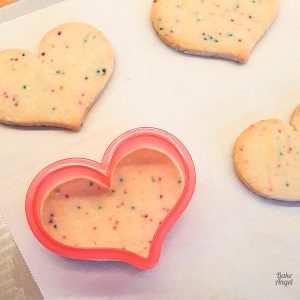 Close up of funfetti no spread sugar cookies, with one cutter on a cookie to show its sharp edges.
