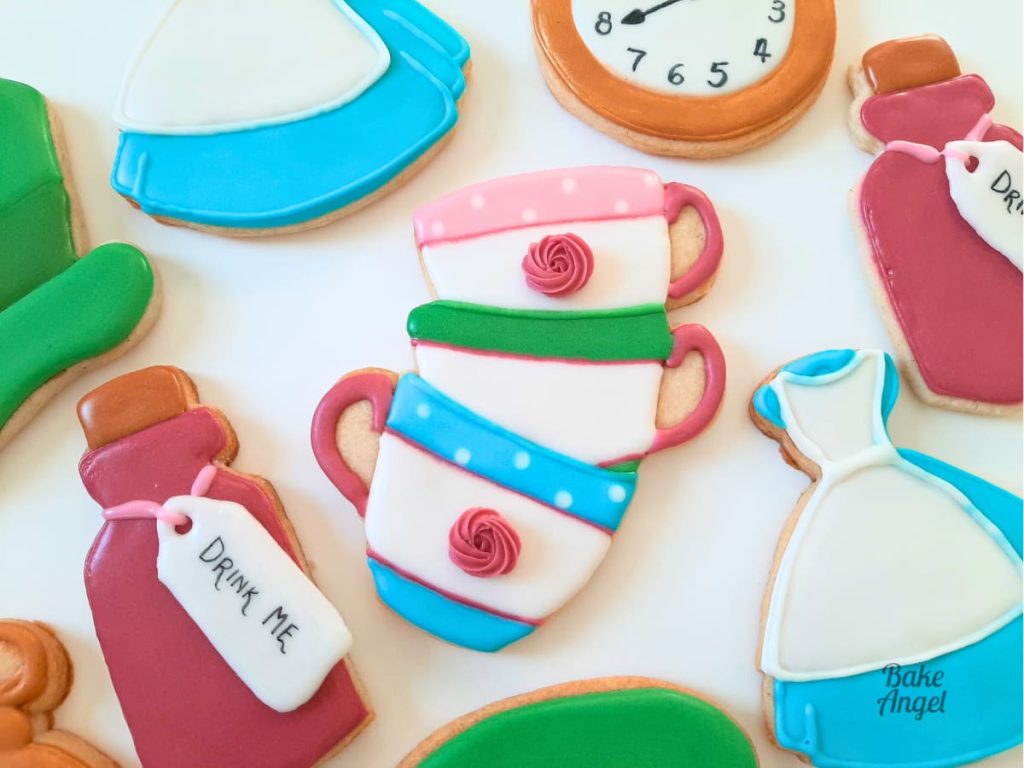 Alice in Wonderland themed vegan no-chill sugar cookies decorated with royal icing, tutorial available on Bake Angel YouTube channel.