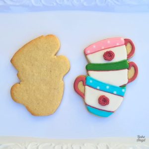 Two cookies on a white tray, one undecorated and one decorated with royal icing.