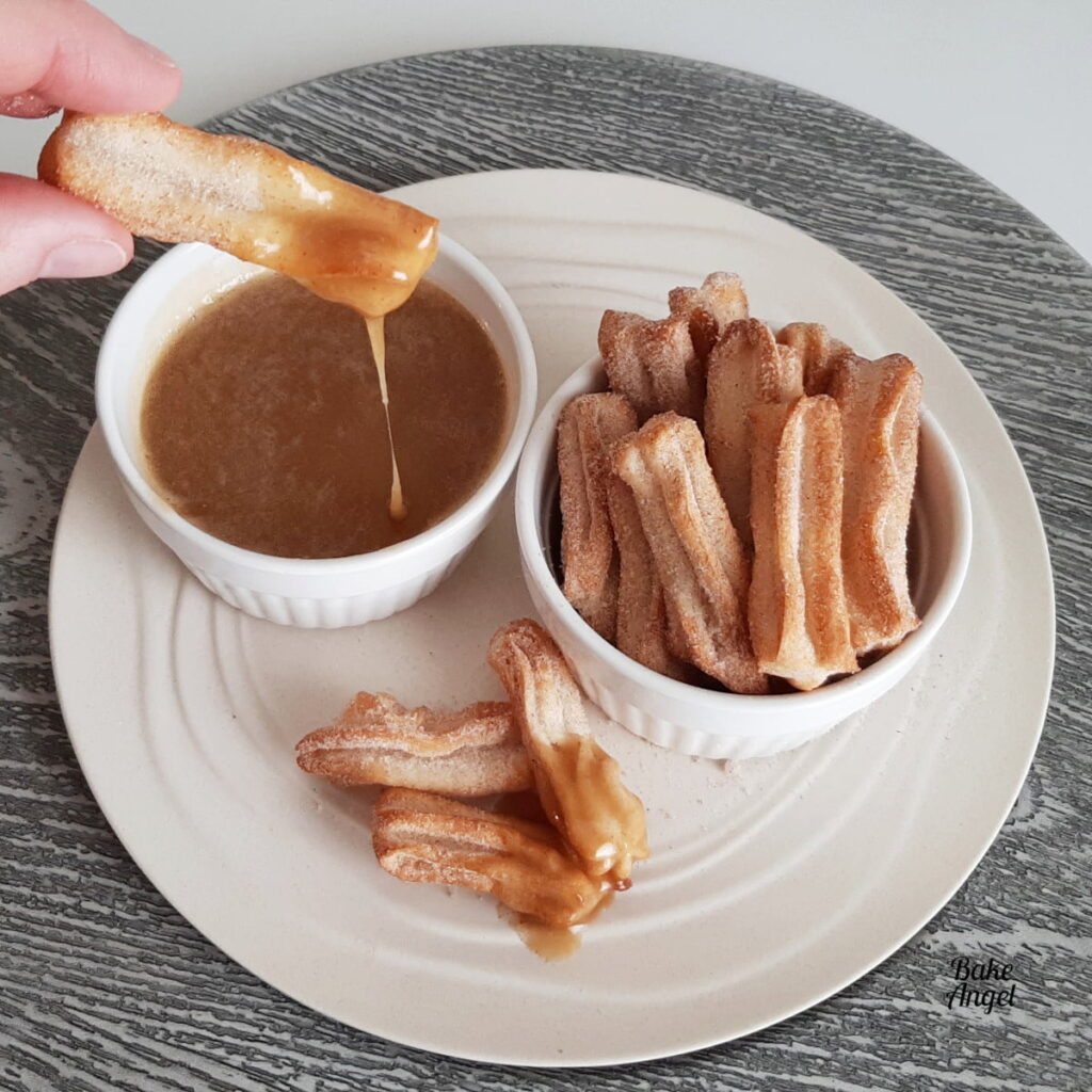Warm cinnamon sugar churro bites served in a bowl, perfect handheld dessert for summer BBQs and family gatherings.