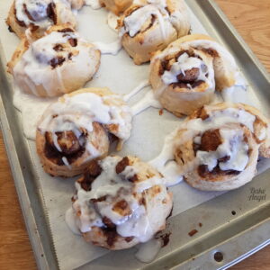 Freshly glazed brown sugar vegan cinnamon rolls on a tray.
