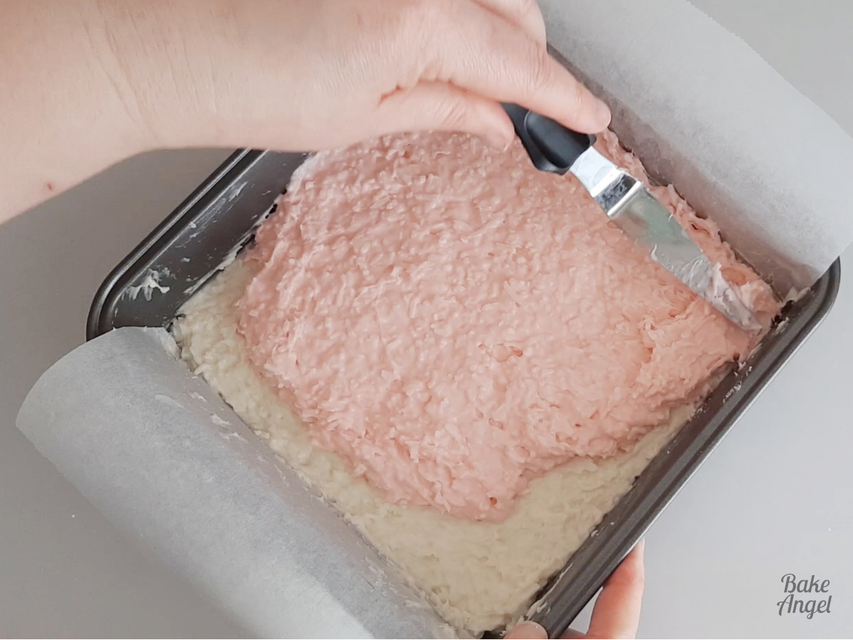 Spreading out the pink coconut ice with a tapered spatula. 