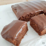 Close up of two slices of chocolate fudge cake on a white plate.