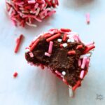 Close up of the inside of a vegan cocoa truffle, coated in sprinkles.
