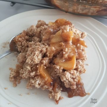 Close up of gluten free vegan peach crumble on a white plate.