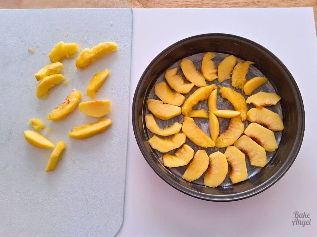 Pattern of sliced peaches arranged in a cake pan before baking an upside down cake.