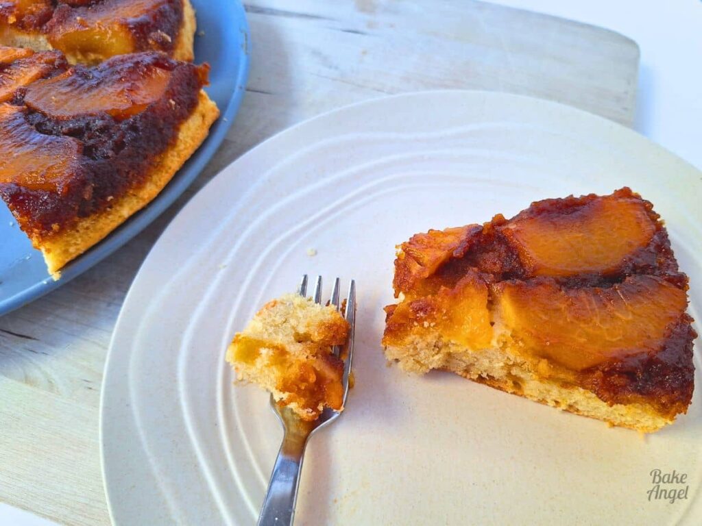 Slice of dairy free peach upside down cake served on a plate.