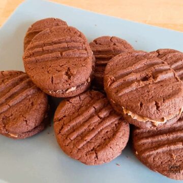 Close up of chocolate cookie sandwiches on a blue plate.