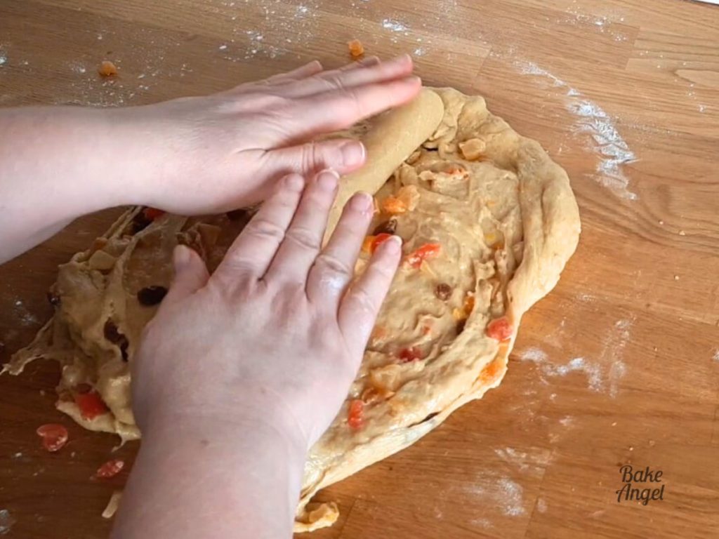 Adding a roll of marzipan to stollen dough.