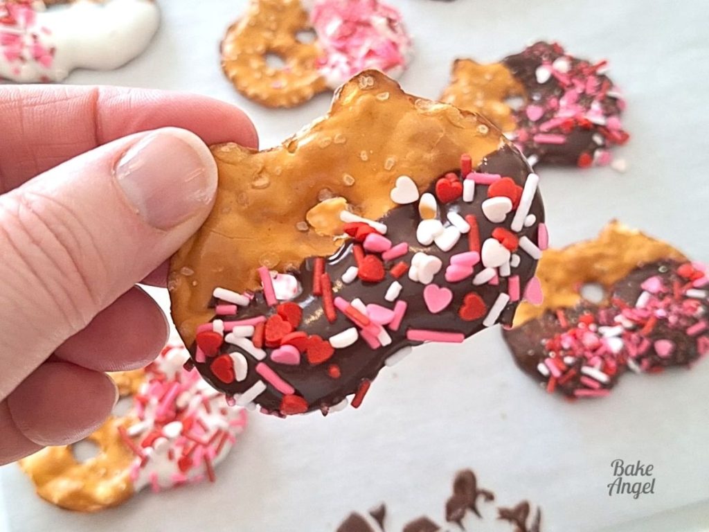 Close up of a chocolate dipped pretzel with Valentine's sprinkles.