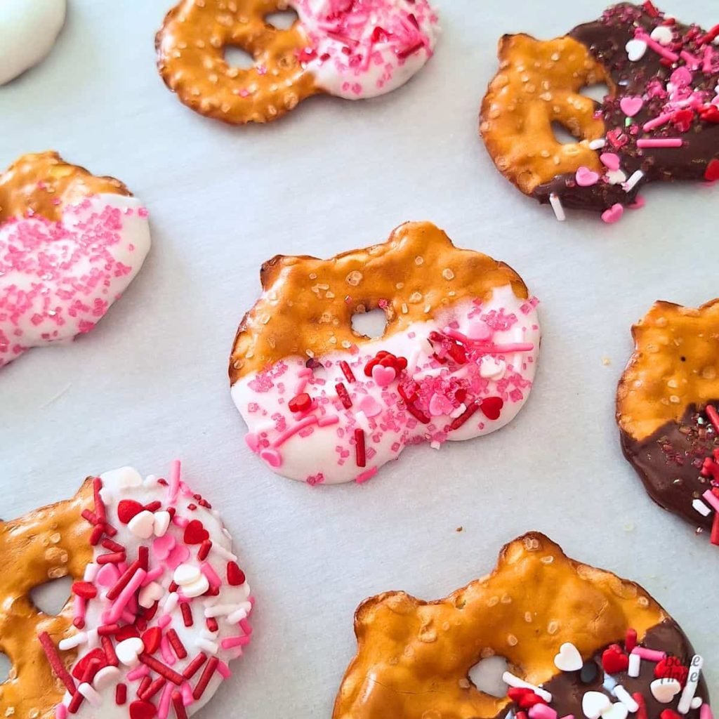 Current image: Close up of chocolate covered pretzels with Valentine's Day sprinkles.