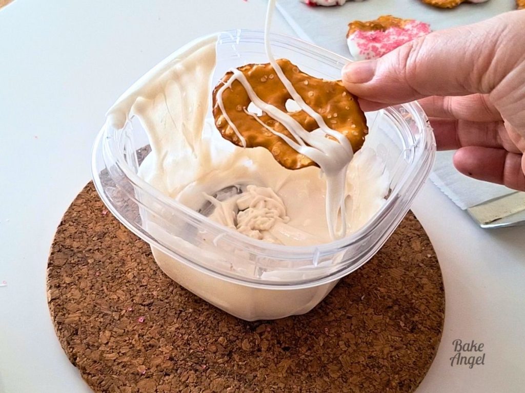 Drizzling white chocolate on to a pretzel crisp.