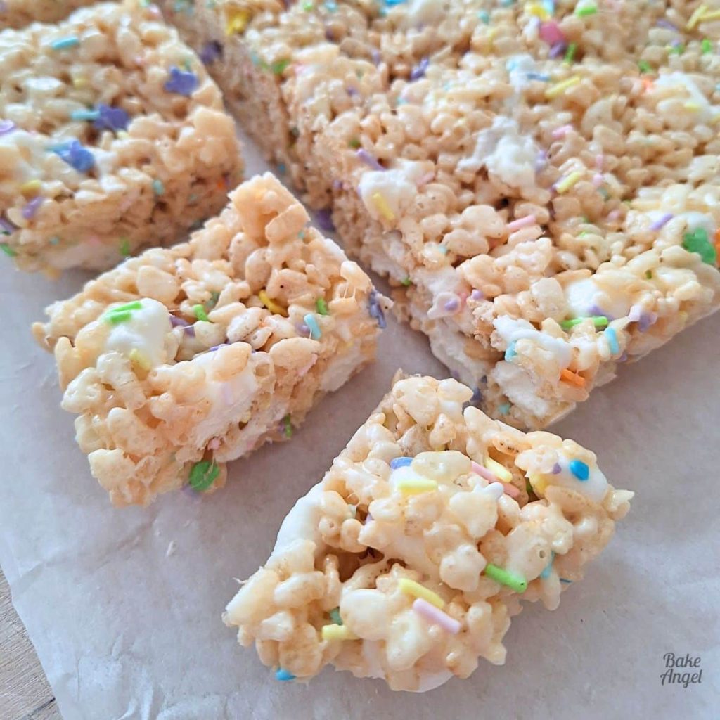 Current image: Dairy-free Easter Rice Krispie Treats cut into squares on parchment paper.