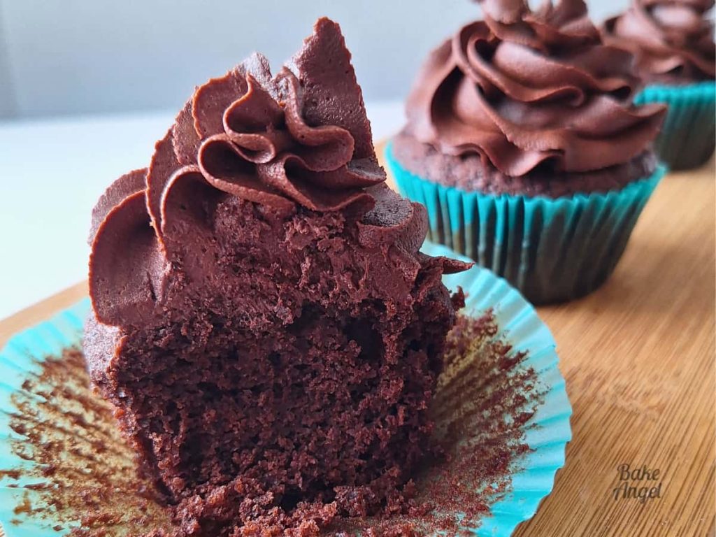 Close up of a chocolate cupcake cut in half and frosted with Stable Dairy-Free Chocolate Buttercream.
