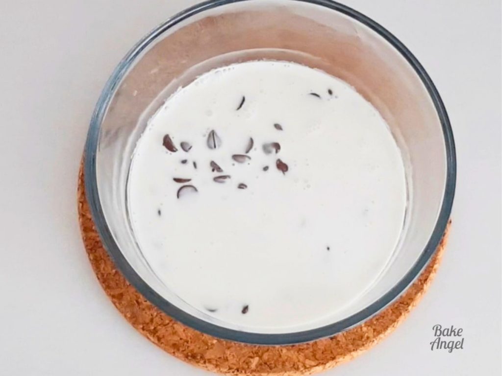 Hot coconut cream and chocolate chips in a small bowl.