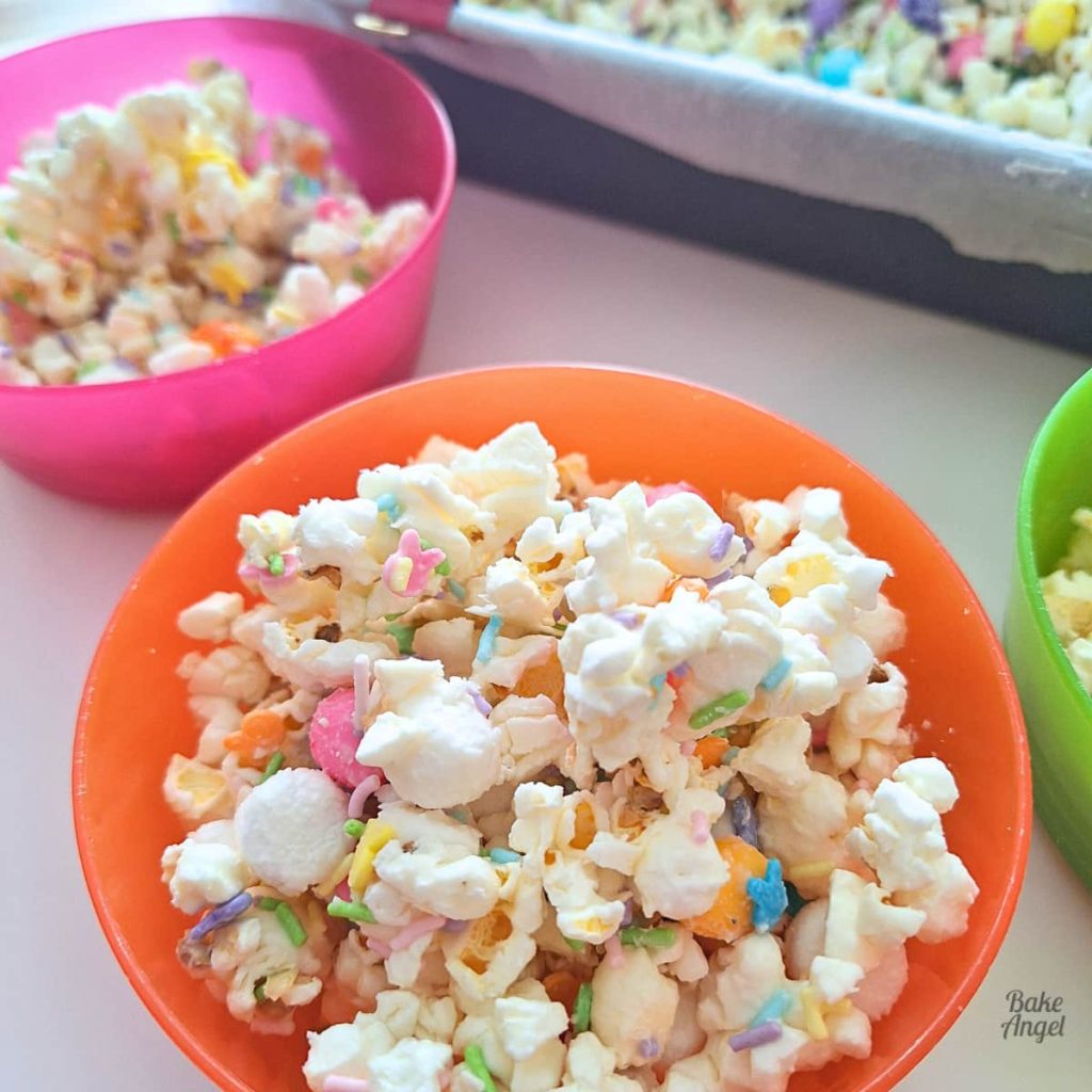 Close up of Easter Bunny Bait popcorn with sprinkles marshmallows and chocolate drizzle.