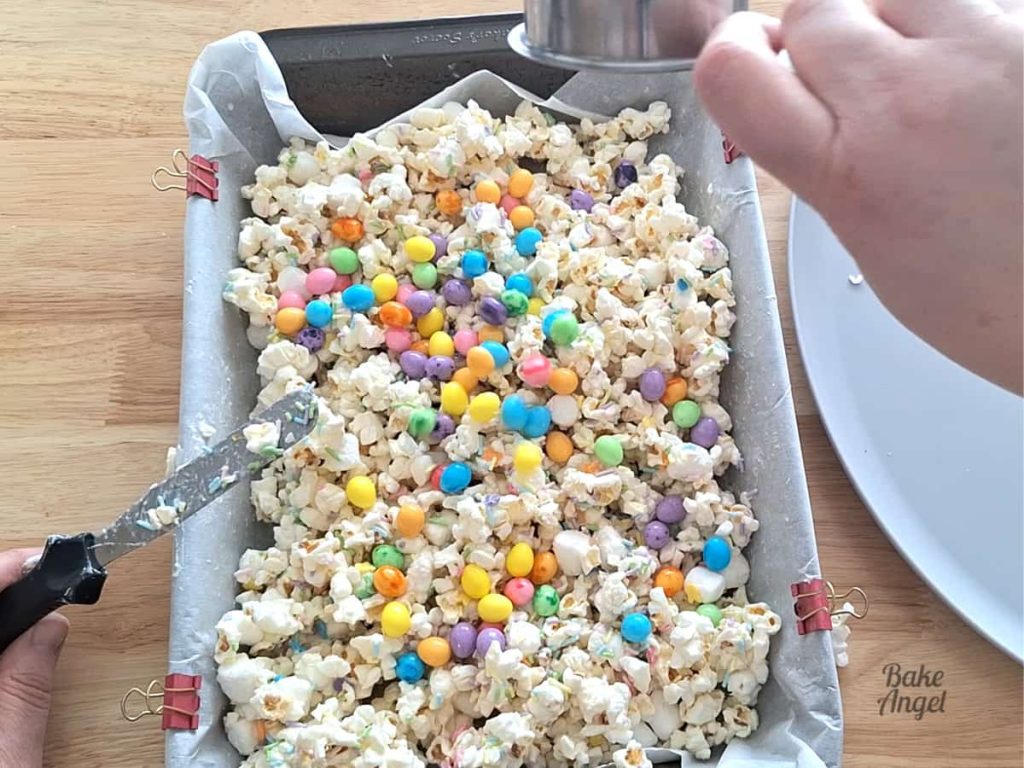 Mixing Easter candies into bunny bait popcorn.