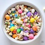 Close up of a bowl of Easter Bunny Bait Popcorn with colourful sprinkles and Easter egg candies.