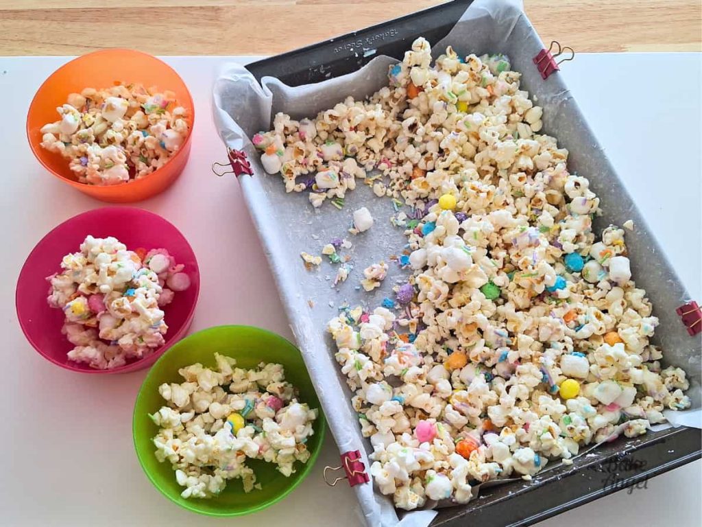 Three bowls of Bunny Bait popcorn next to the pan of popcorn.