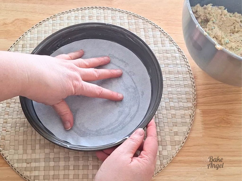 Placing a parchment circle in the 9 inch baking pan.