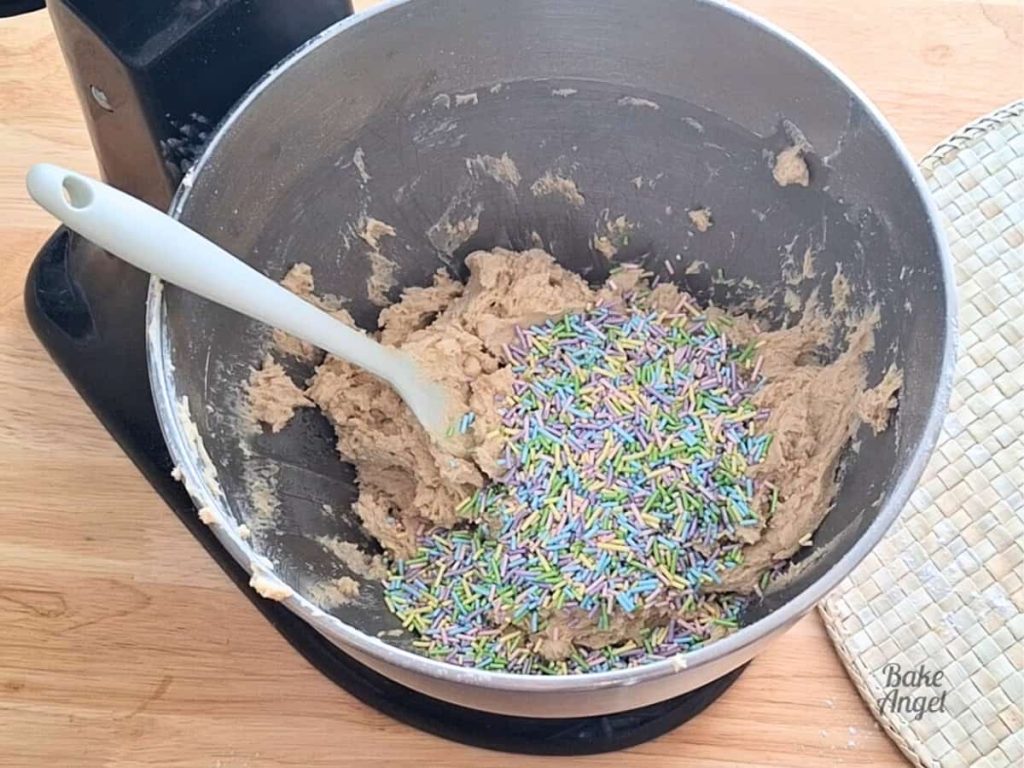 Easter sprinkles on cookie dough in a mixing bowl.