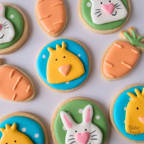 Close up of selection of Easter sugar cookies decorated with royal icing as carrots, bunny and chicks.