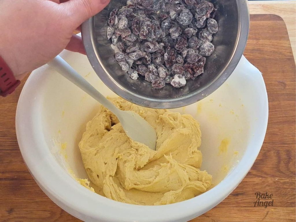 Floured cranberries being added to lemon flavoured dairy-free cake batter.