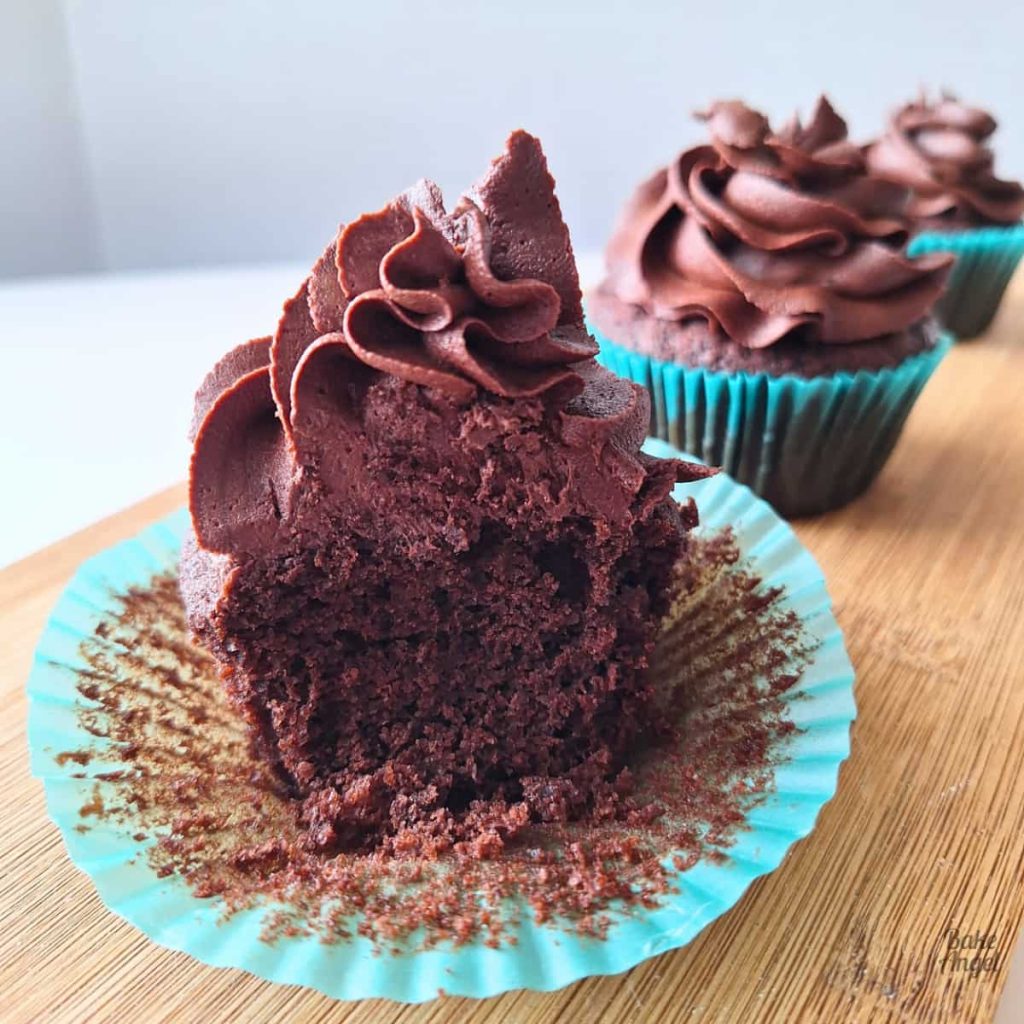 Current image: Close up of a decorated chocolate cupcakes after a bite has been taken.