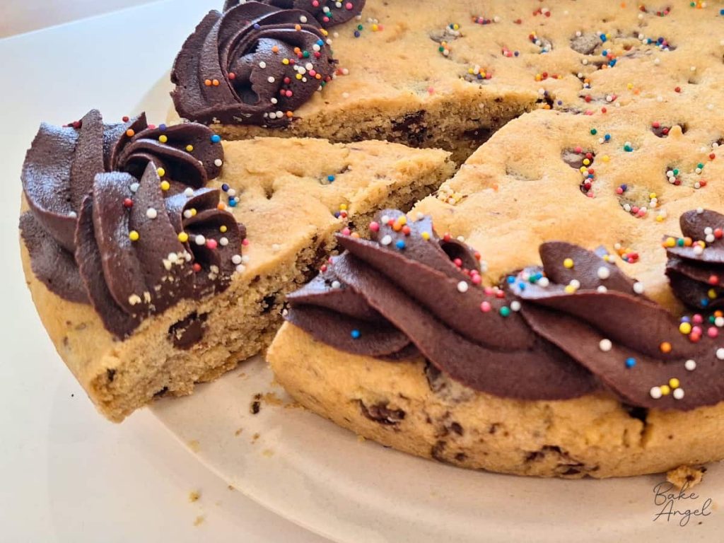 A slice of dairy free chocolate chip cookie cake on a plate.