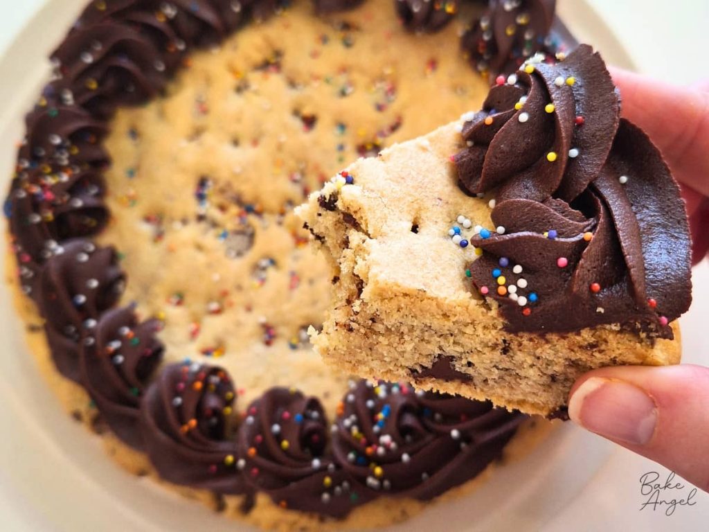 Close up of a dairy free chocolate chip cookie cake slice with a bite taken out