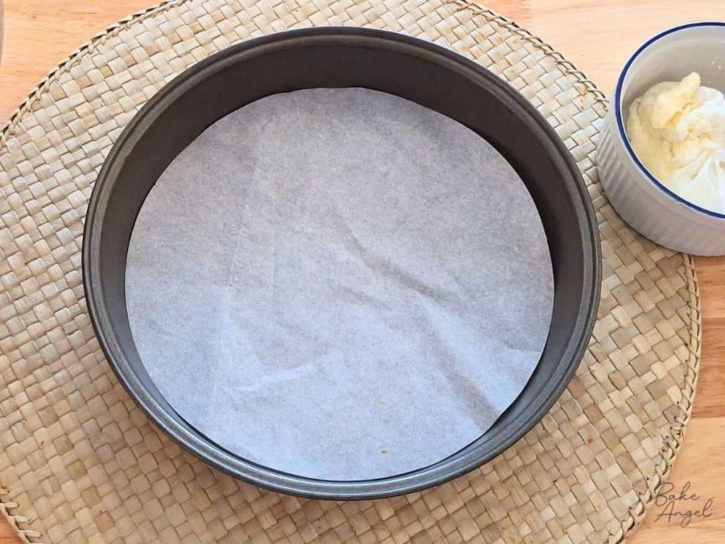 A round cake pan lined with parchment paper.