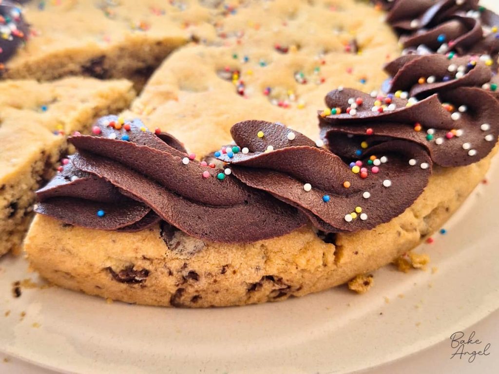 Close up of chocolate buttercream piping on dairy free chocolate chip cookie cake