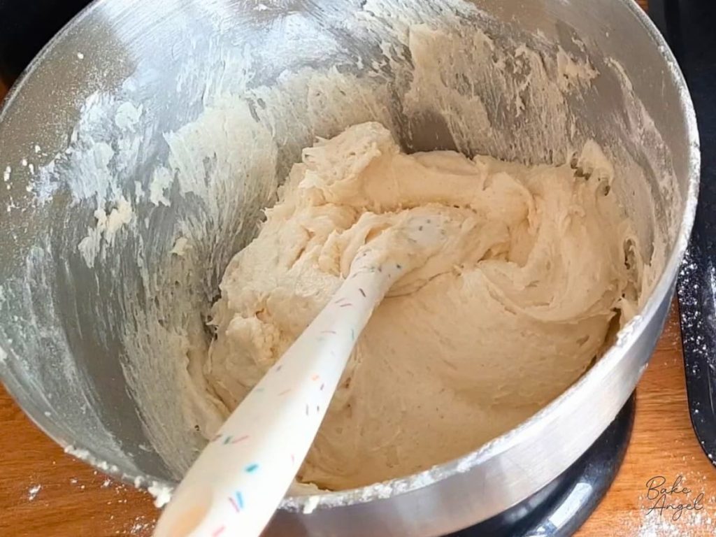 Victoria sponge cake batter in a mixing bowl with a spatula.