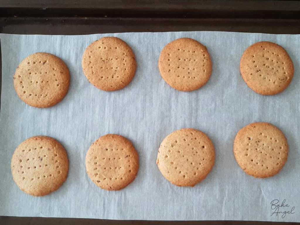 Golden homemade digestive biscuits cooling on a baking tray