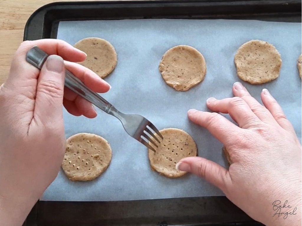 Pricking holes into digestive biscuits with a fork before baking