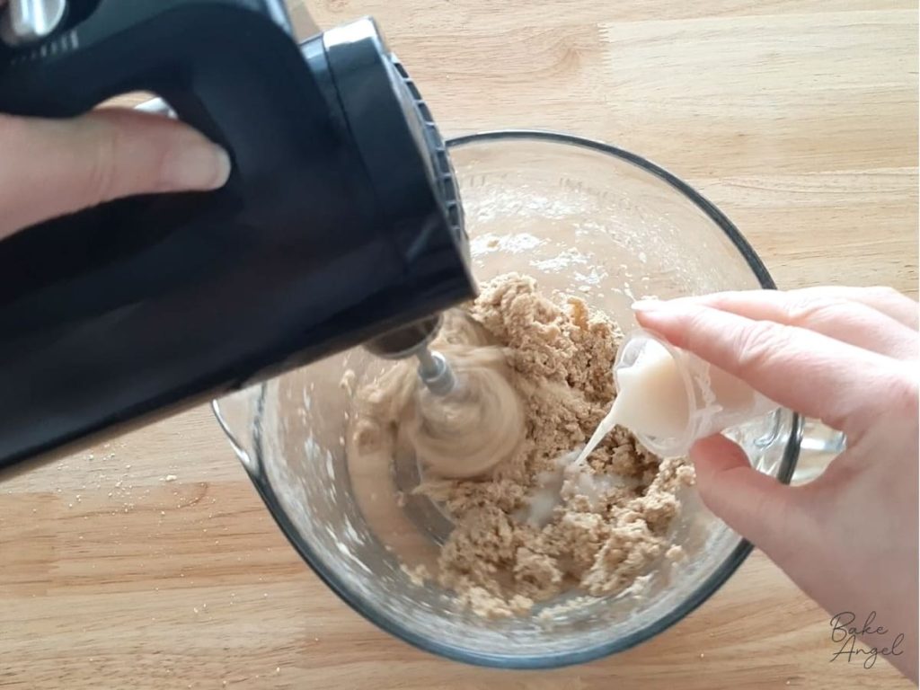 Adding plant based milk to digestive ingredients in a mixing bowl.