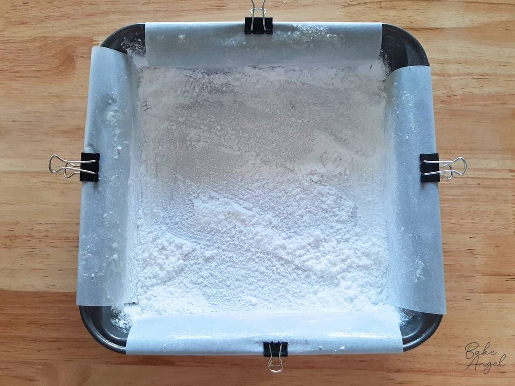 Lined and greased 8 x 8 baking pan coated with icing sugar and cornstarch mixture.