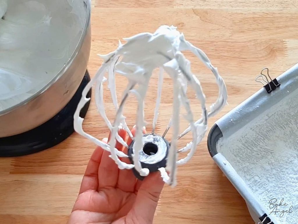 Whipped egg whites on a whisk attachment, for marshmallows.