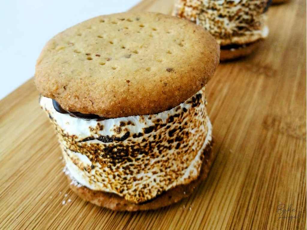 Close up of a toasted s'more, showing the golden brown colouring on the marshmallow and some ganache at the top.