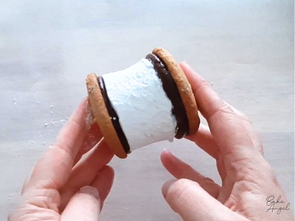 A homemade s'more being held sideways.